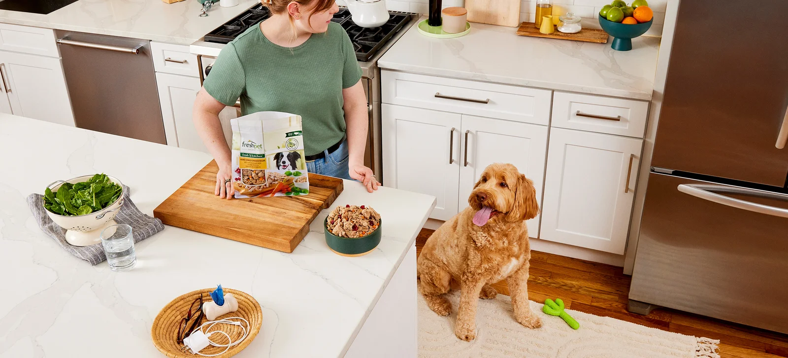 Pet parent serving Freshpet fresh food while her dog waits in the kitchen